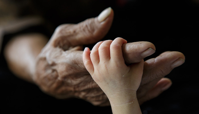 toddler holding grandparents hand