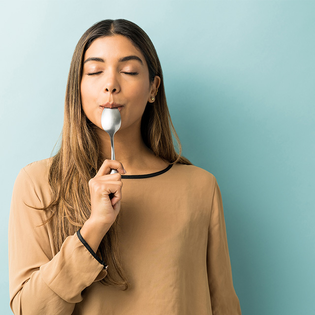 Teenage girl with spoon in her mouth