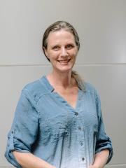 Wendy Mansell Wendy Mansell in a blue shirt standing in front of a grey background