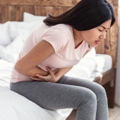 lady doubled over with pain clutching stomach