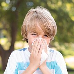 Young boy blows his nose