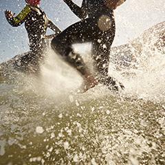 Triathletes running on beach