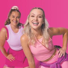 Two women dressed in various shades of pink activewear pose for a photo