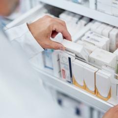 Pharmacist opening drawer of medicines 