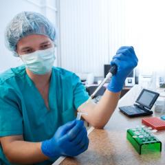 Person in scrubs pipetting