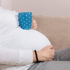 Pregnant lady with coffee cup on tummy